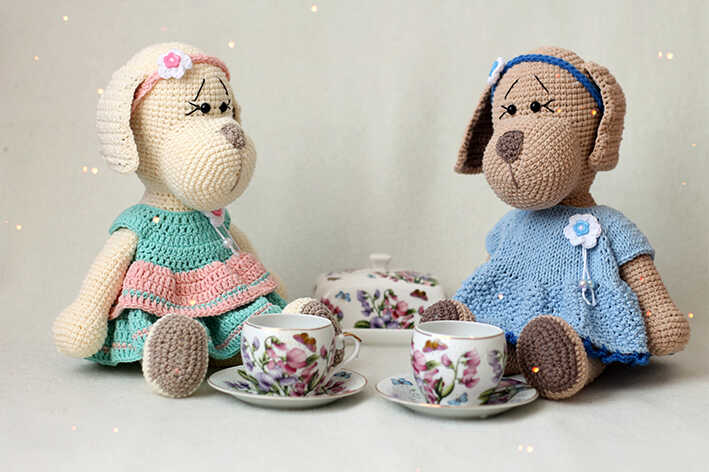 An aesthetic visualization of two amigurumi puppies during a tea party, providing a professional preview for our free guide. It acts as a stylistic reference to inspire your creative handmade doll projects. We offer this artistic concept to showcase the charm of the finished pattern.