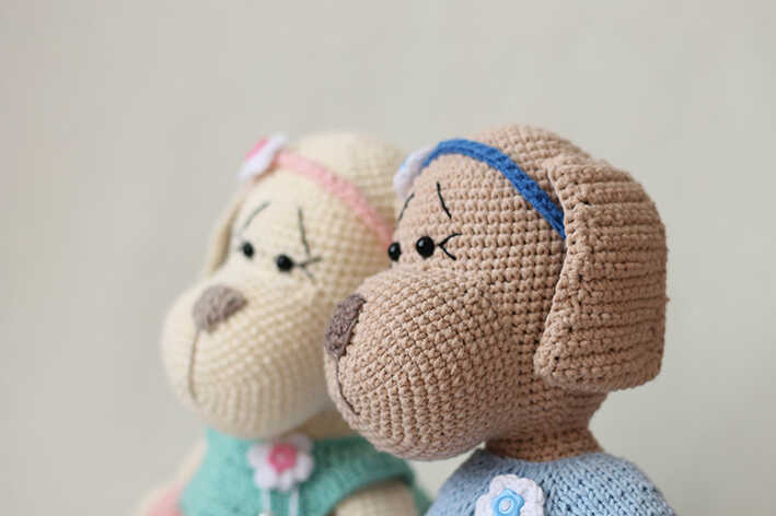 A detailed visualization focusing on the facial profile of the amigurumi puppies, serving as a high-quality preview of our free pattern. This image captures the needlework to provide a stylistic reference for your work. We share this concept as a professional guide for handmade toy lovers.