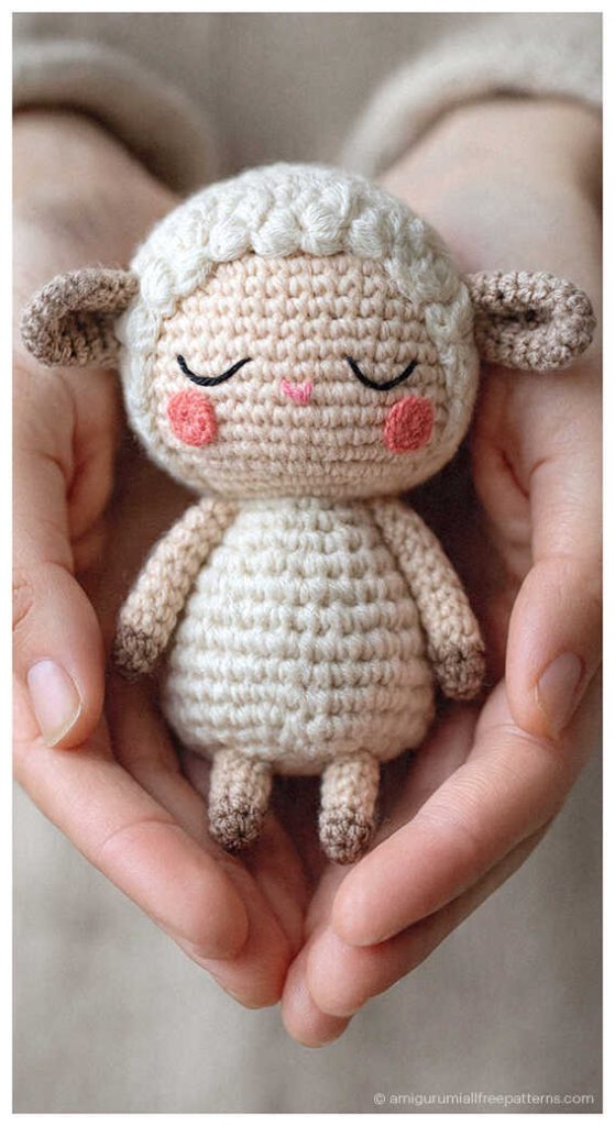 Adorable lamb amigurumi crochet toy with sleepy face held in hands, soft handmade plush design perfect for nursery decor or a sweet baby gift.