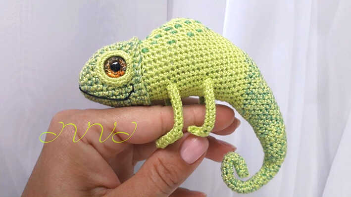 Cute chameleon amigurumi crochet toy in green yarn held in hand, detailed handmade lizard design, free crochet pattern for unique gifts and decor.