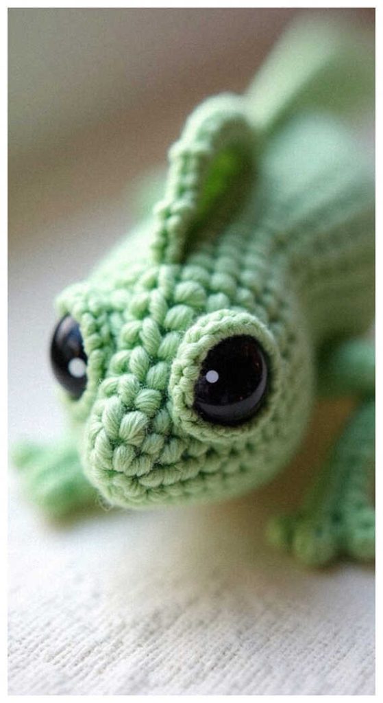 Chameleon amigurumi crochet doll close up with big eyes, so cute it grabs attention instantly, free pattern available in the link for handmade decor.