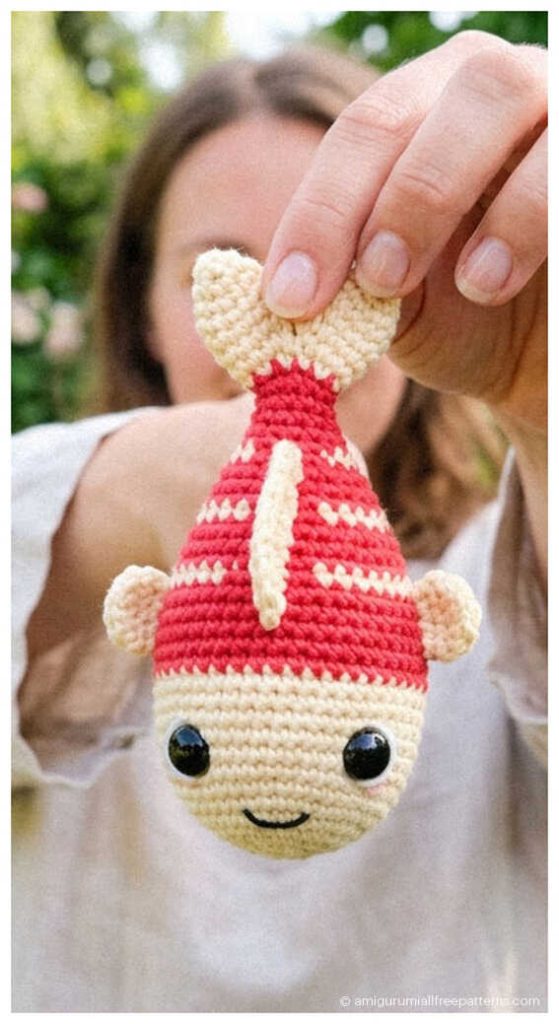 Fish amigurumi crochet toy held upside down, cute handmade plush you’ll want to make for nursery decor or a fun crochet gift.
