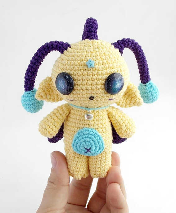 Cute alien friend amigurumi crochet doll with big galaxy eyes and colorful details, handmade space themed plush toy, free crochet pattern for a unique gift idea.