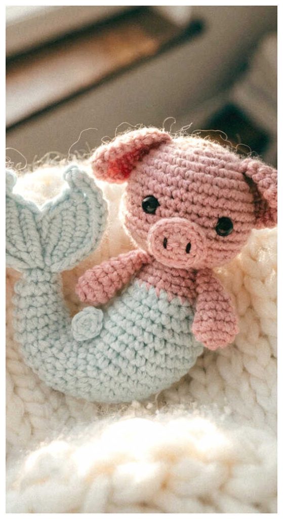 Baby pig mermaid amigurumi resting in a cozy nursery style setting