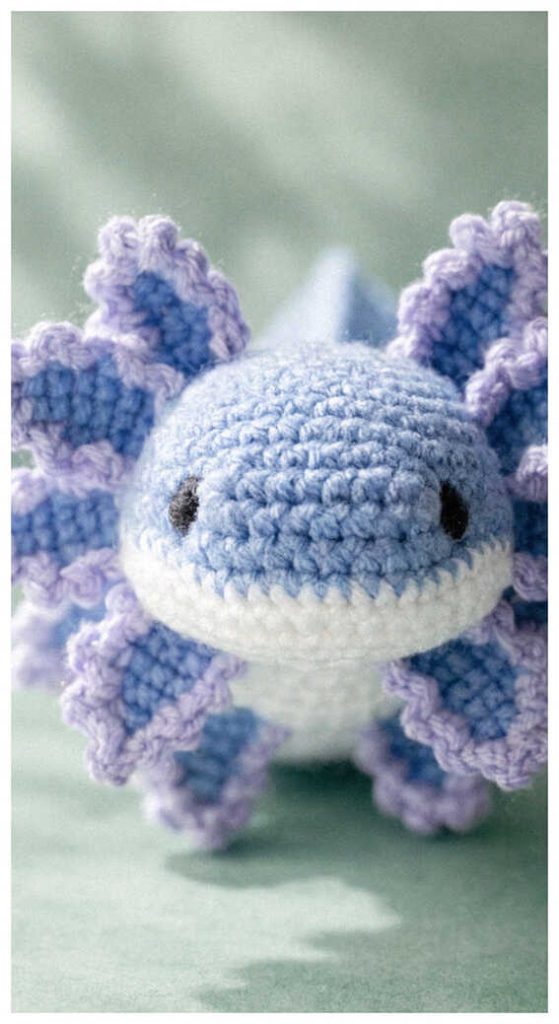 Blue axolotl amigurumi plush displayed in soft natural lighting