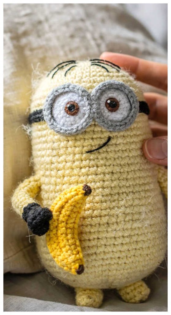 Cute minion crochet plush held in hand in a cozy indoor setting