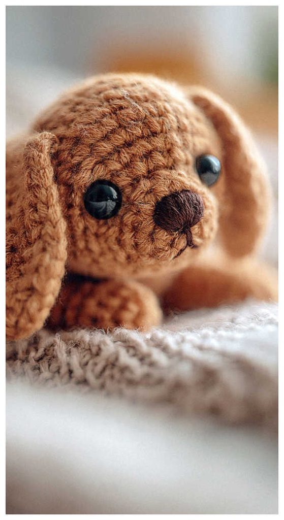 Fluffy puppy amigurumi plush resting in a cozy close up setting