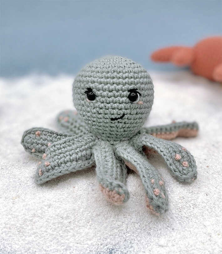 Octopus amigurumi crochet plush displayed in soft beach inspired lighting