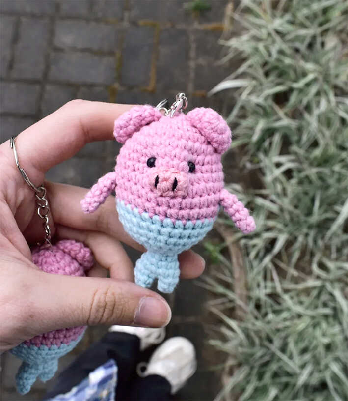 Pig mermaid crochet keychain amigurumi held in hand outdoors