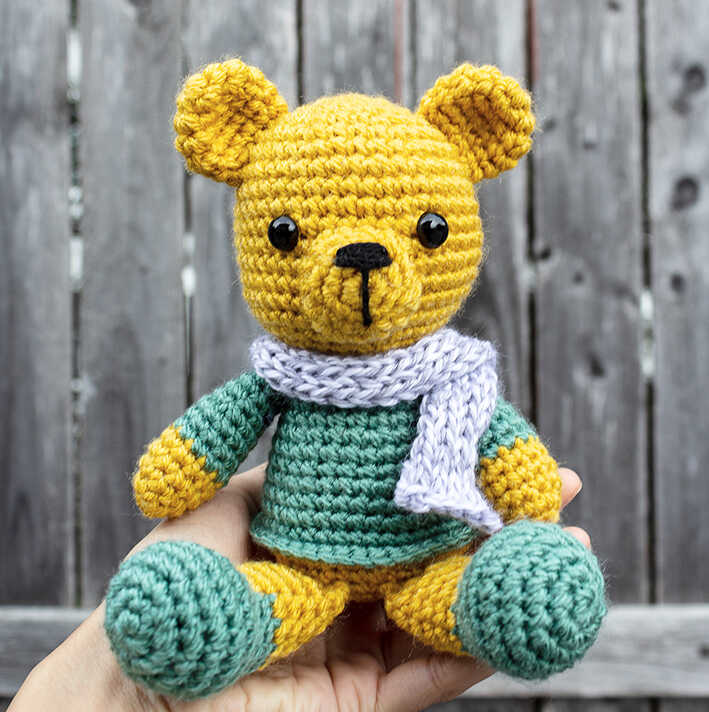 Timothy crochet bear amigurumi plush held in hand with scarf