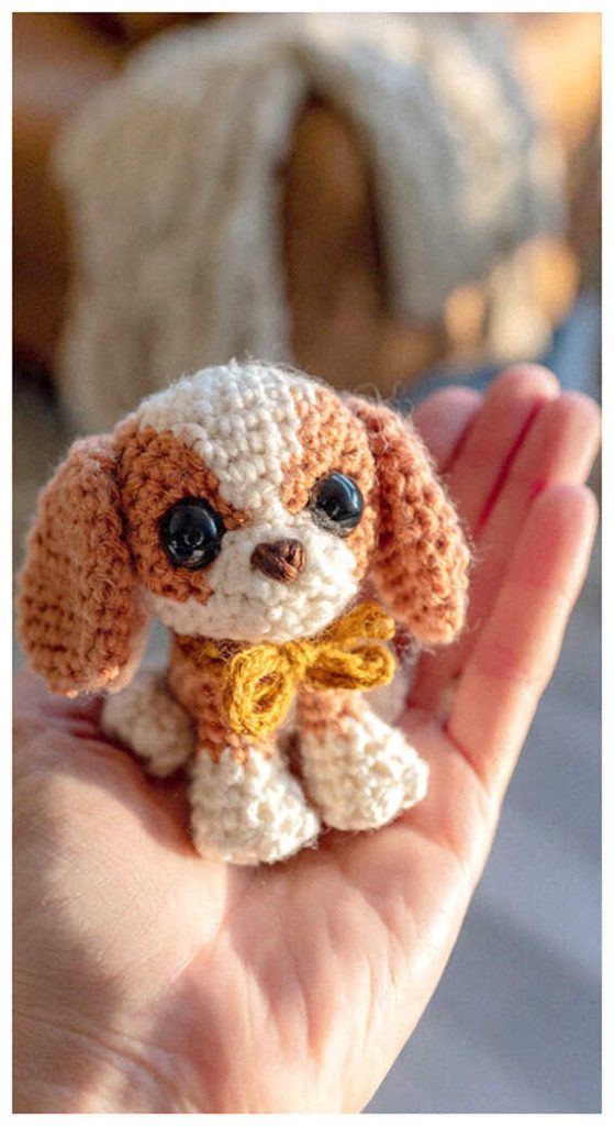 Tiny puppy amigurumi plush held in hand in soft natural lighting