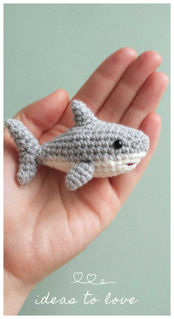 Tiny shark amigurumi crochet plush toy held in hand