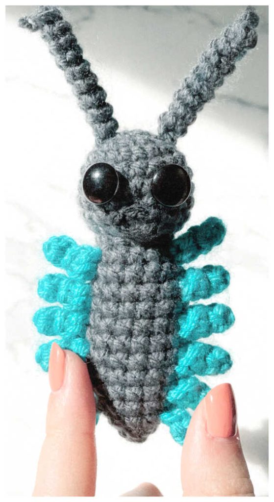 Teal insect amigurumi plush in a bright cozy setting