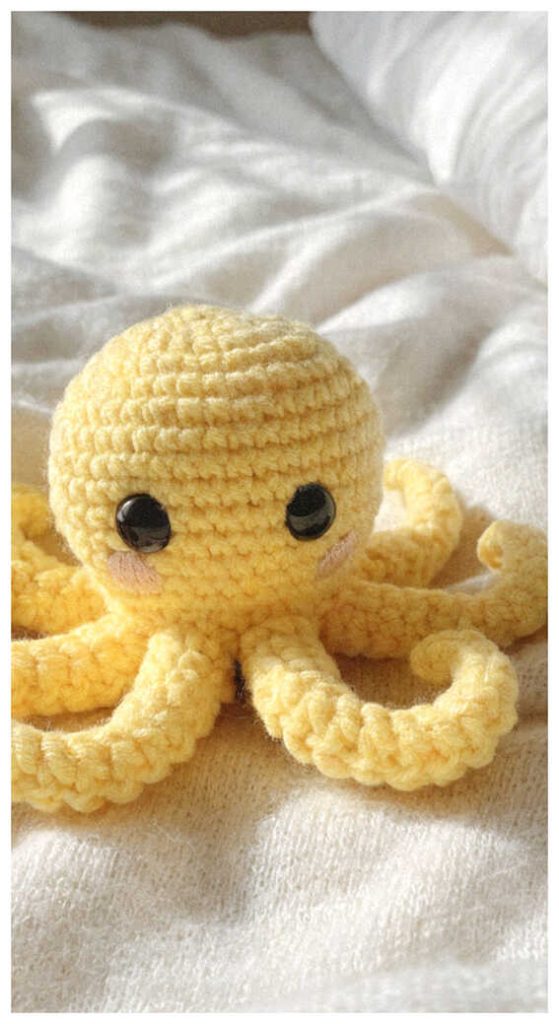 Yellow octopus crochet plush resting in a cozy indoor setting