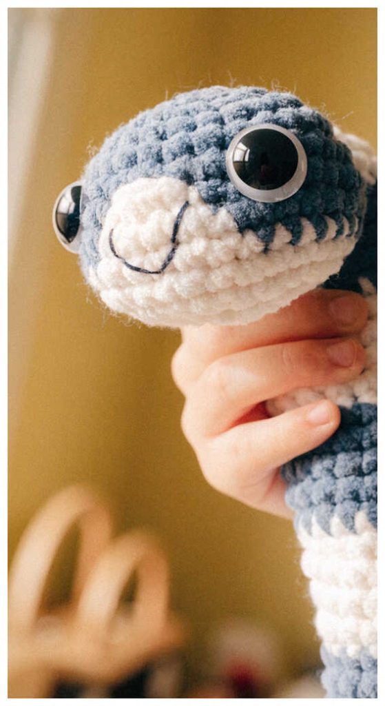 Small snake crochet plush toy held in hand